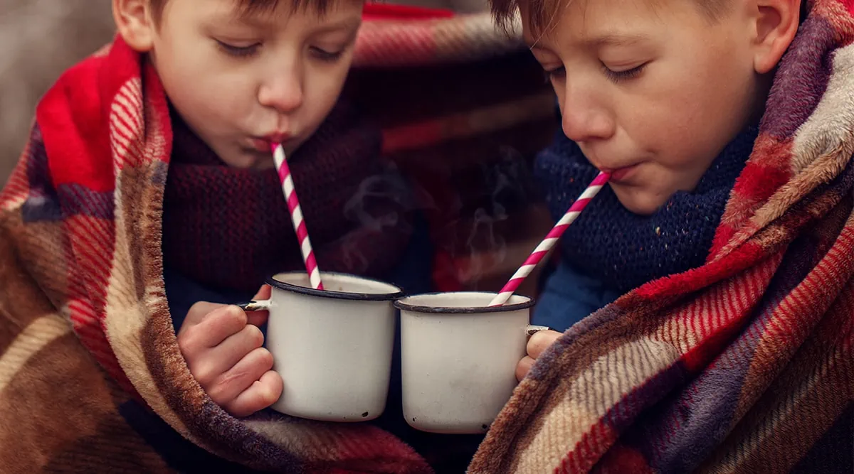 two boys drinking hot chocolate straws