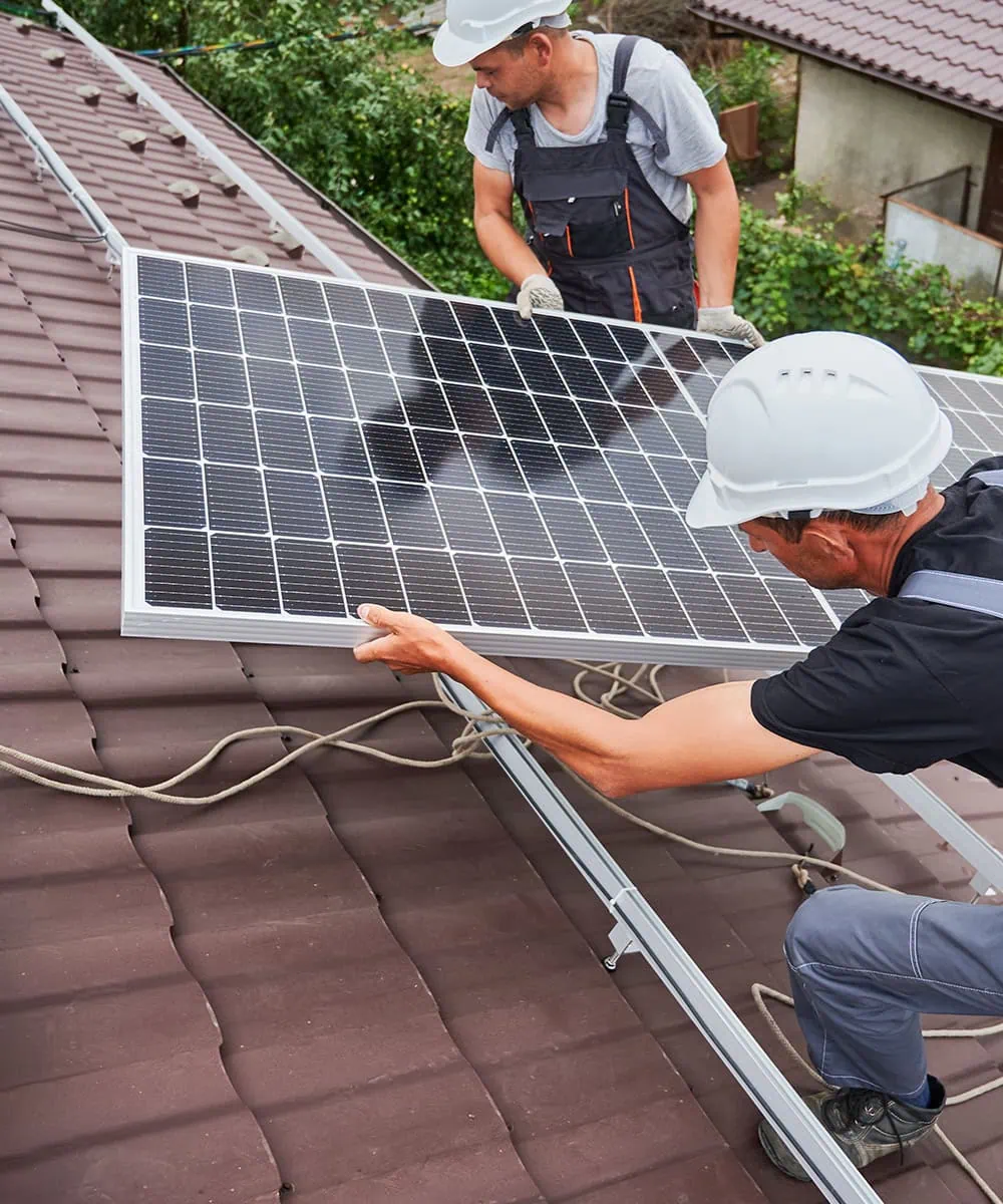 Workers installing solar panels on a roof.