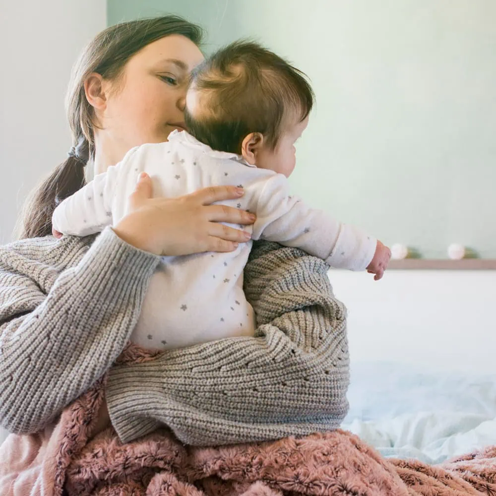 Mother holding baby on shoulder